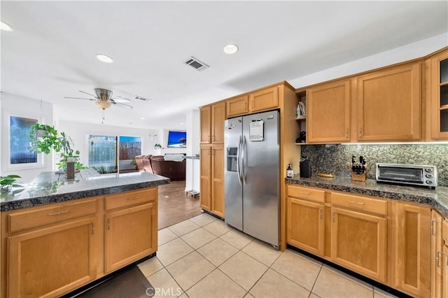 kitchen with ceiling fan, stainless steel fridge, decorative backsplash, and light tile patterned floors