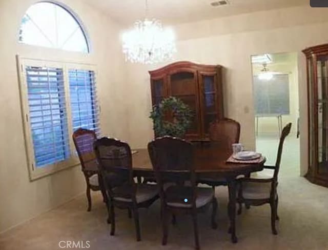 dining room featuring carpet floors and an inviting chandelier