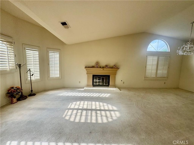 unfurnished living room with a chandelier, vaulted ceiling, and light carpet