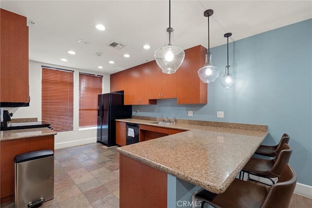 kitchen with hanging light fixtures, a breakfast bar area, black appliances, and kitchen peninsula