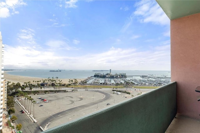 balcony featuring a view of the beach and a water view