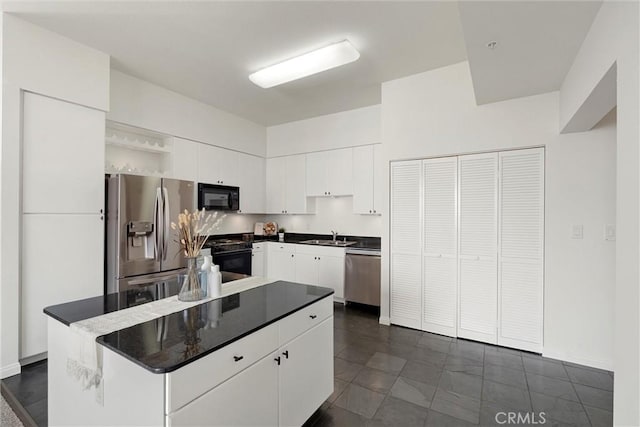 kitchen featuring white cabinetry, sink, stainless steel appliances, and a center island