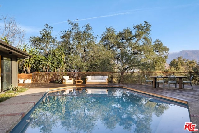 view of swimming pool featuring a deck with mountain view