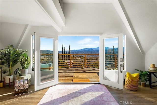 doorway with beamed ceiling, wood finished floors, and a mountain view