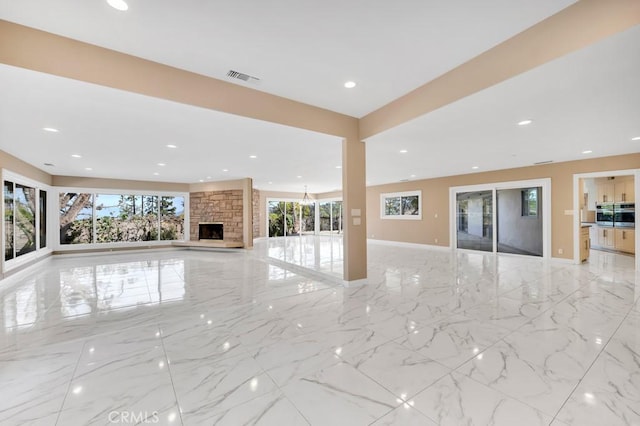 unfurnished living room featuring a stone fireplace