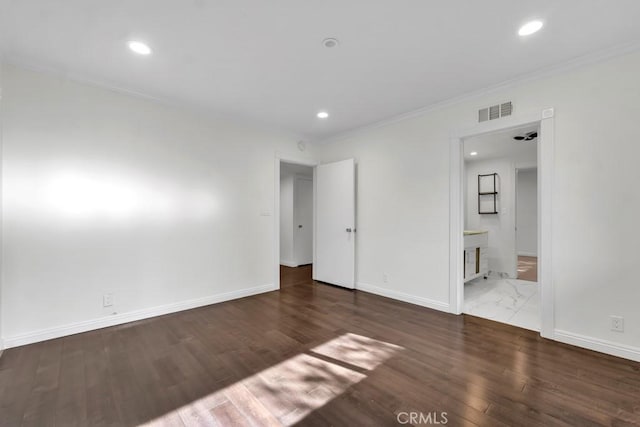 spare room with dark hardwood / wood-style flooring and crown molding