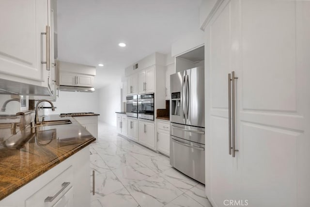 kitchen featuring white cabinetry, appliances with stainless steel finishes, sink, and dark stone countertops