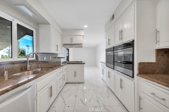 kitchen with tasteful backsplash, stainless steel appliances, sink, and white cabinets