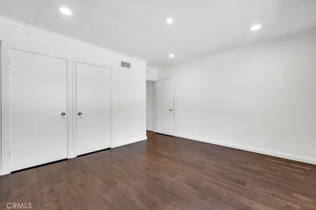 unfurnished bedroom featuring crown molding and dark hardwood / wood-style flooring