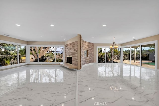 unfurnished living room with a fireplace and a chandelier