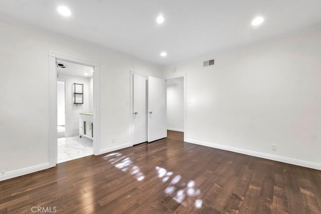 unfurnished bedroom with wood-type flooring and ensuite bath