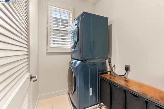 washroom with stacked washer / dryer and light tile patterned floors