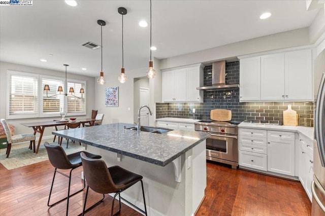 kitchen with white cabinetry, sink, high end stainless steel range, and wall chimney exhaust hood