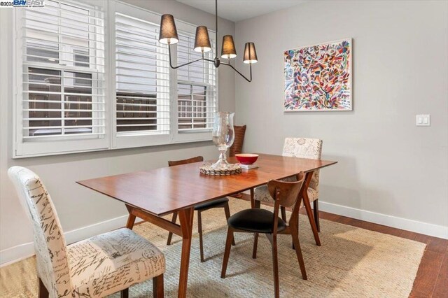 dining area featuring hardwood / wood-style flooring and a notable chandelier