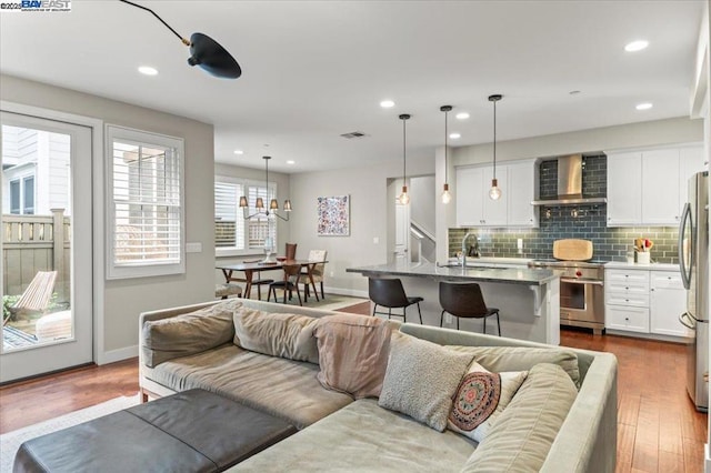 living room with sink, hardwood / wood-style floors, and a chandelier