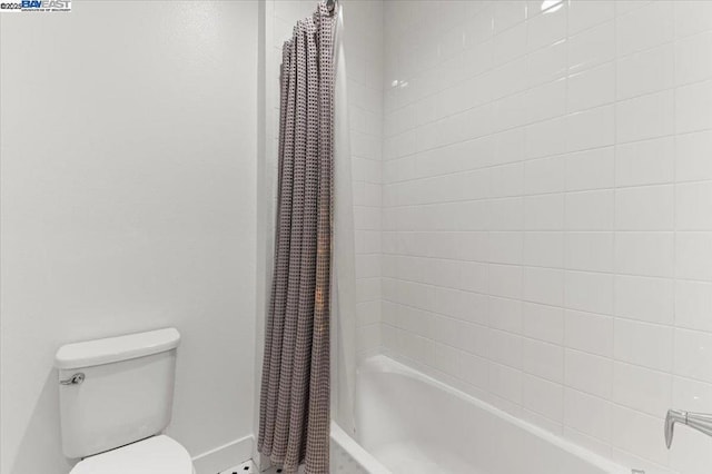 bathroom with shower / bath combination with curtain and toilet