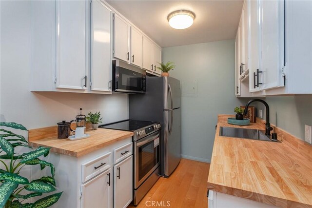 kitchen featuring white cabinetry, appliances with stainless steel finishes, sink, and light wood-type flooring