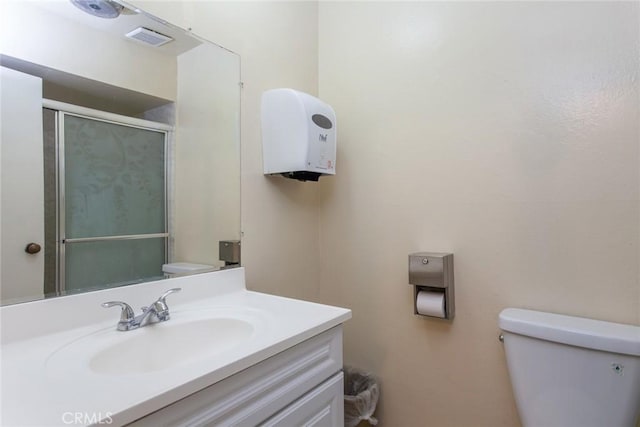 bathroom featuring visible vents, a shower stall, toilet, and vanity