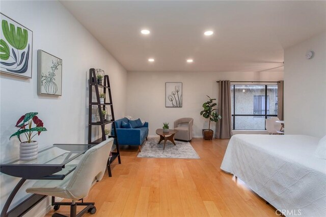 bedroom with recessed lighting, light wood-style floors, and baseboards