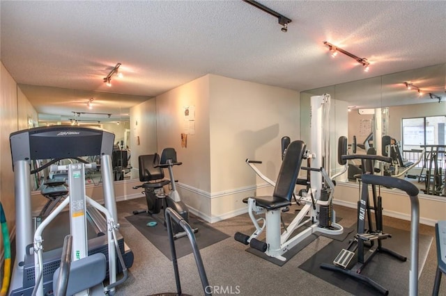 gym featuring track lighting and a textured ceiling