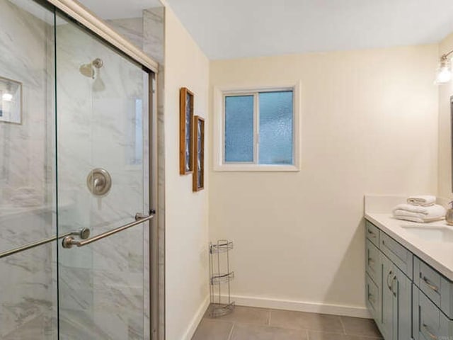 bathroom with baseboards, vanity, tile patterned floors, and a stall shower