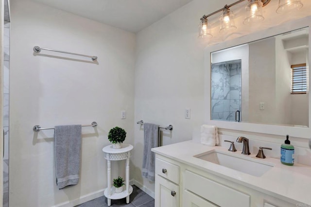 bathroom with baseboards, vanity, tile patterned flooring, and a stall shower