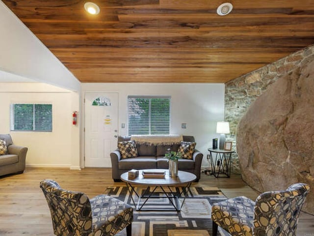 living area with wood ceiling, lofted ceiling, wood finished floors, and baseboards