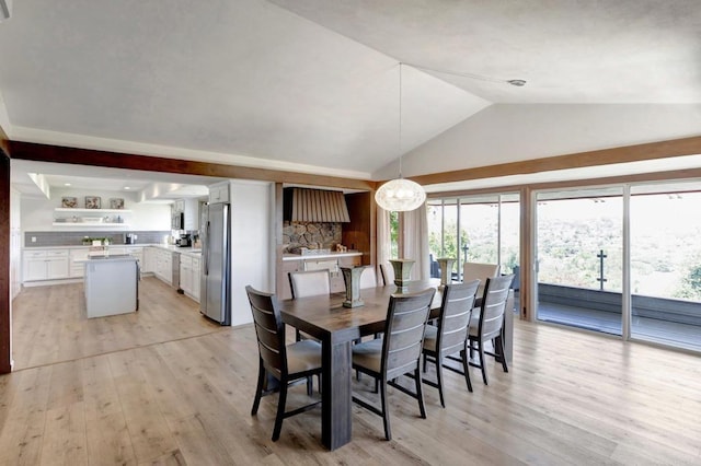 dining space featuring lofted ceiling, a notable chandelier, and light wood-style floors