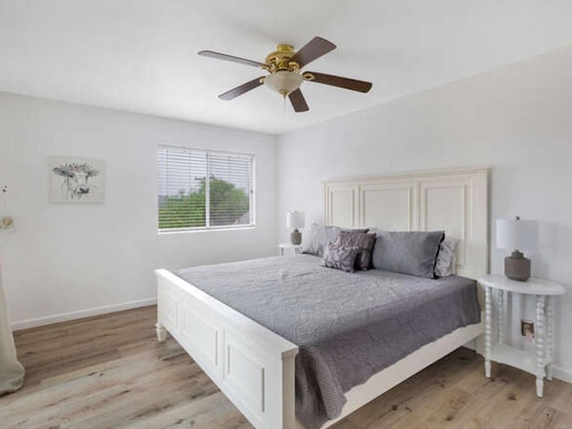bedroom featuring light wood-type flooring, a ceiling fan, and baseboards