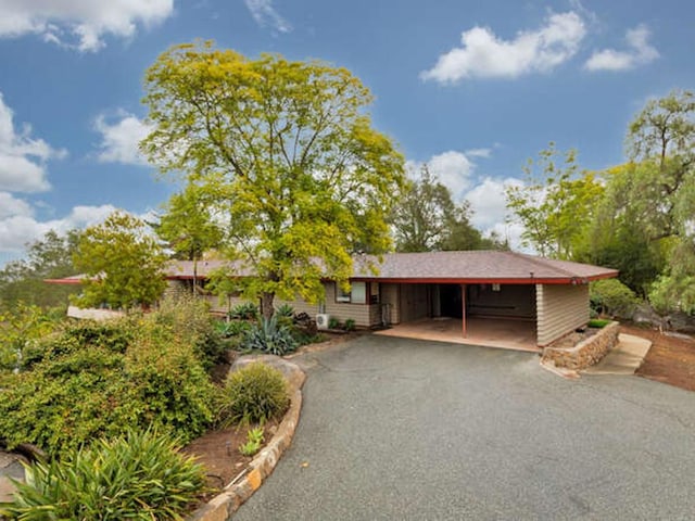 single story home featuring aphalt driveway and an attached carport