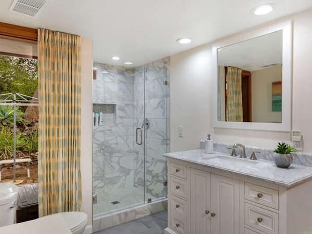 bathroom featuring tile patterned floors, a marble finish shower, visible vents, recessed lighting, and vanity