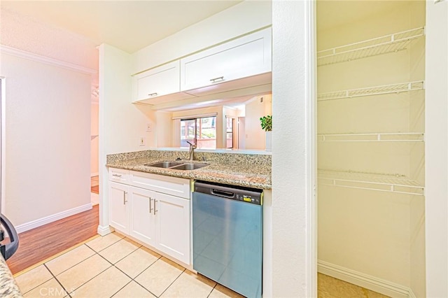 kitchen featuring light tile patterned flooring, sink, light stone counters, dishwasher, and white cabinets