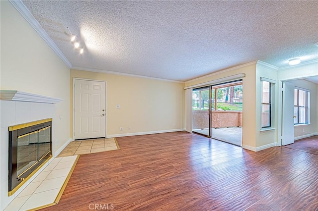 unfurnished living room with ornamental molding, a fireplace, and light hardwood / wood-style flooring