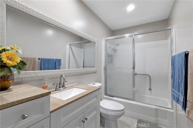 full bathroom featuring vanity, bath / shower combo with glass door, tile patterned floors, and toilet