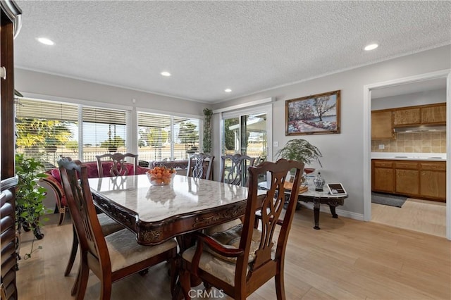 dining area featuring a textured ceiling and light hardwood / wood-style floors