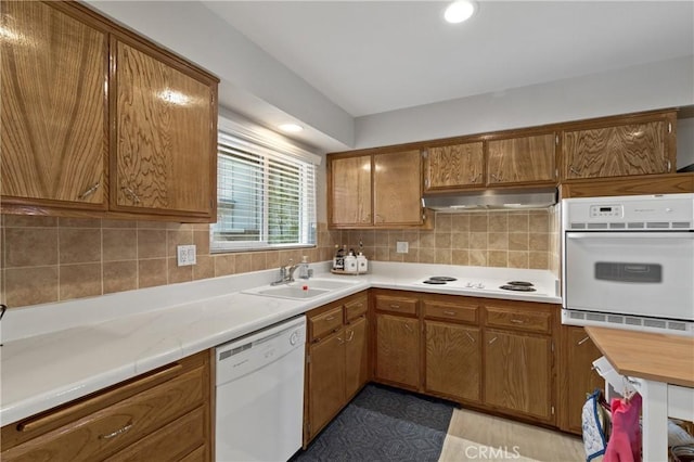 kitchen featuring sink, white appliances, and backsplash