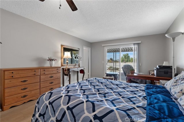 bedroom featuring a textured ceiling, hardwood / wood-style floors, access to exterior, and ceiling fan