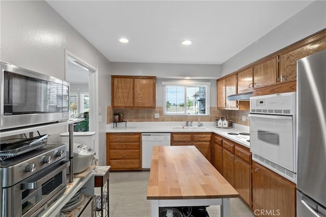 kitchen with wood counters, sink, backsplash, and appliances with stainless steel finishes