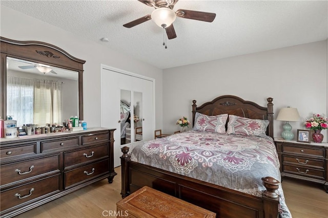 bedroom with ceiling fan, a textured ceiling, and light wood-type flooring