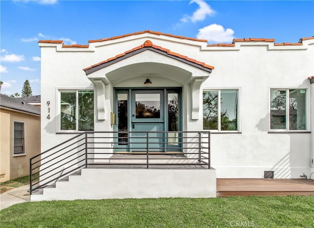 view of exterior entry with a yard