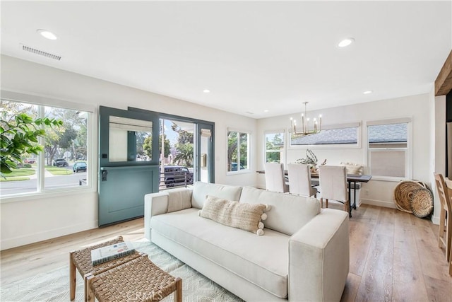 living room featuring a notable chandelier and light hardwood / wood-style floors