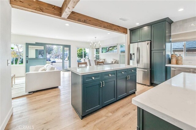 kitchen featuring a kitchen island, hanging light fixtures, light hardwood / wood-style floors, stainless steel refrigerator with ice dispenser, and beam ceiling