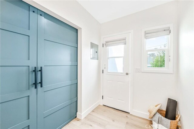 doorway featuring electric panel and light wood-type flooring