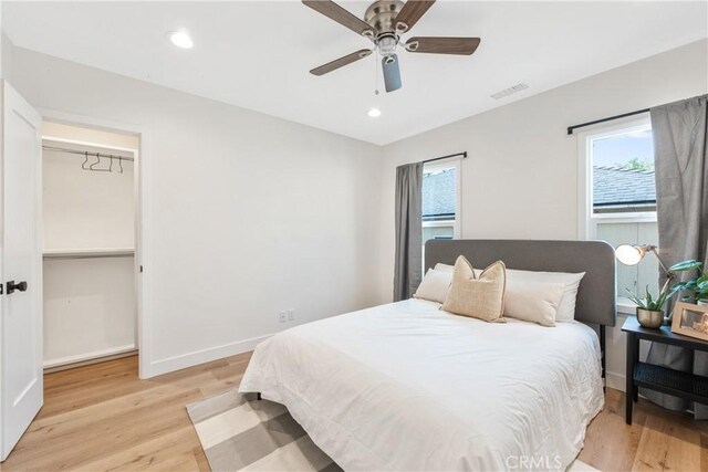 bedroom with multiple windows, ceiling fan, and light hardwood / wood-style flooring