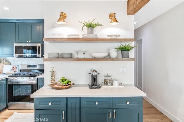 bar with appliances with stainless steel finishes, blue cabinetry, and light hardwood / wood-style floors