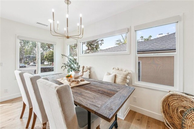 dining space with an inviting chandelier and light hardwood / wood-style floors