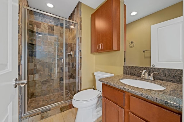 bathroom featuring vanity, toilet, and walk in shower