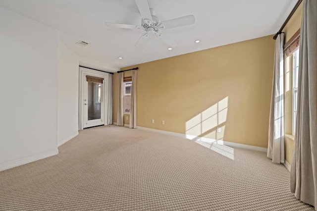 spare room with light colored carpet and ceiling fan