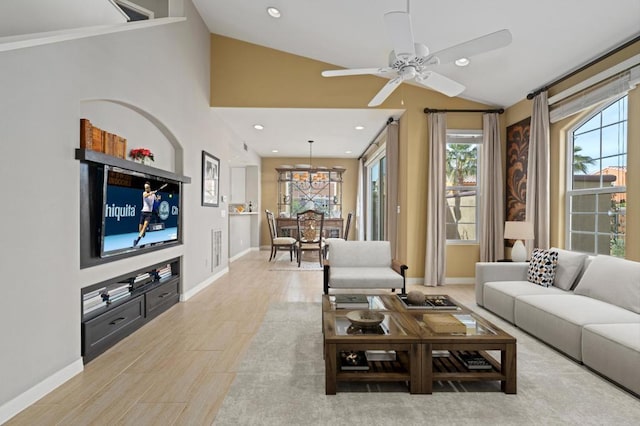 living room with light hardwood / wood-style flooring, vaulted ceiling, and ceiling fan