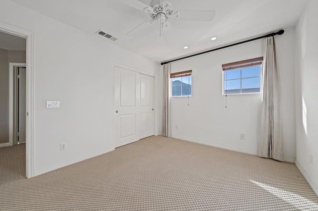 empty room with ceiling fan and light carpet